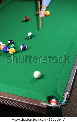 Sinking a ball during a pool game on a felt covered table