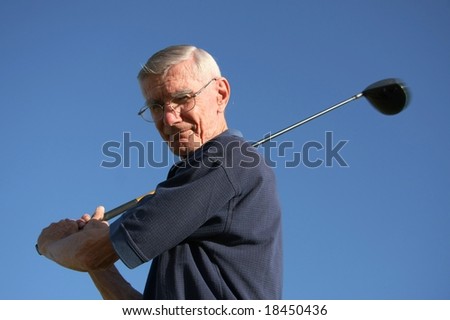 Senior golfer with club against blue sky