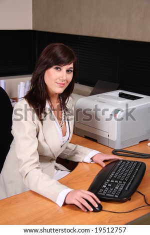 Beautiful secretary at her desk with keyboard and mouse