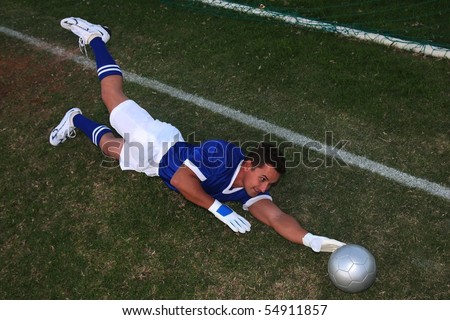Soccer goalkeeper diving to stop the ball