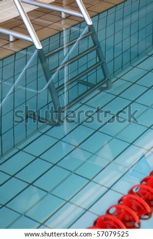 Aluminum steel steps leading into clean blue swimming pool water