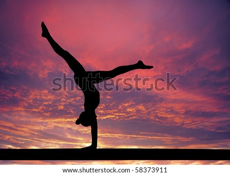 Outline of a gymnast girl in balance on a beam at sunset.