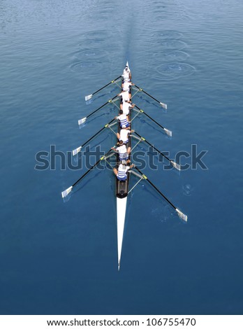Eight young sportsmen rowing  on a sunny day