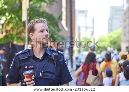 TORONTO, ONTARIO/CANADA - JULY 13: A cop walking by road on the day of 41st Annual Festival of India on July 13, 2013 in Toronto,Canada.