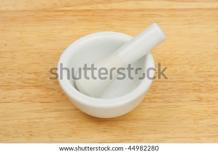 White pestle and mortar on a wooden board