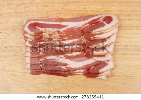 Rashers of streaky bacon on a wooden board