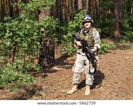 Soldier in ACU holding the Colt M4 carbine with M203 grenade launcher