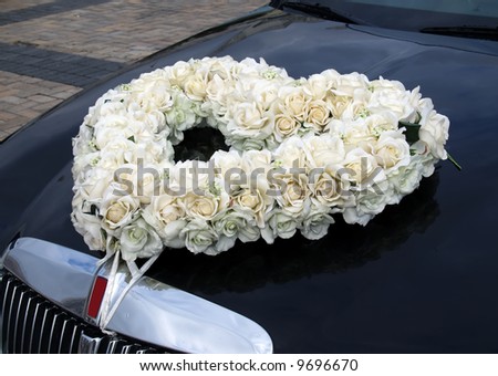 The wedding bunch of flowers on the black limousine hood
