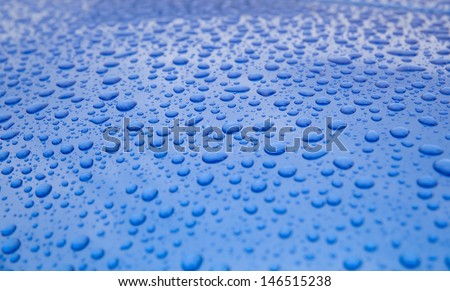 Rain drops on blue metallic surface