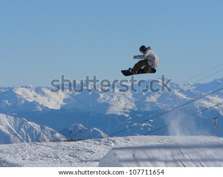 Jumping snowboarder in snow park