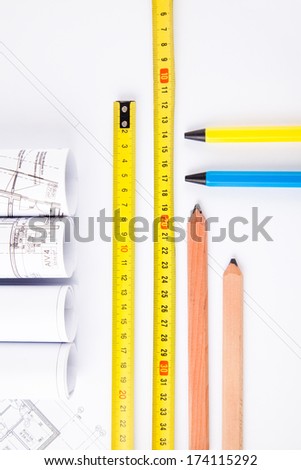 architectural accessories. yellow hardhat, measure, pencils, plans