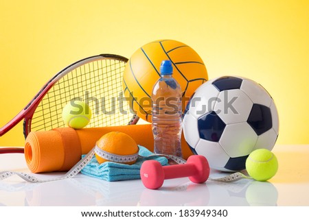 Sport equipment and balls on yellow background