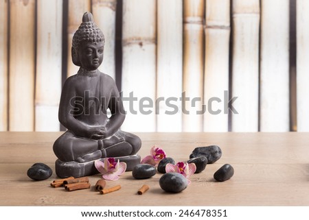 Buddha statue, cinnamon, orchid flowers and zen stones