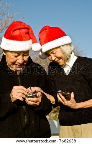 Grandma is teaching Grandpa how to enter data into his new handheld computer he received for Christmas.