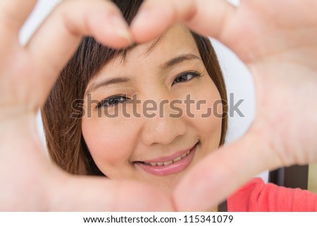 Portrait of a smiling asian girl with frame hands