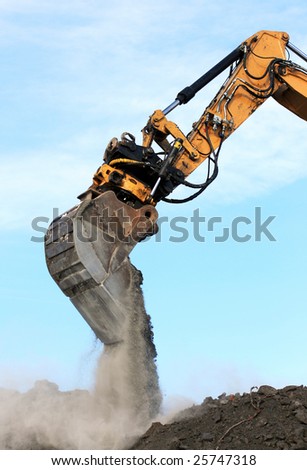 excavator arm and bucket scoop full of dirt at construction site