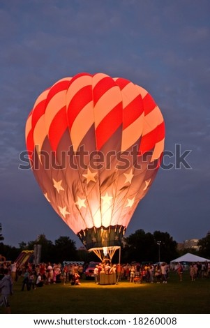 A hot air balloon lighted up in the evening.