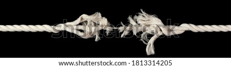 Cotton rope, frayed and ready to break apart with rope held together by last strand ready to snap. Concept of danger or stressful situation like divorce separation, deadlines, failure, or tension.