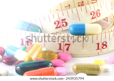 Medicine and Tape Measure on White Background in Waistline and Weight Control Concept.