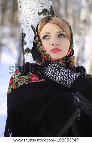 Portrait of a beautiful young woman in a winter birch forest