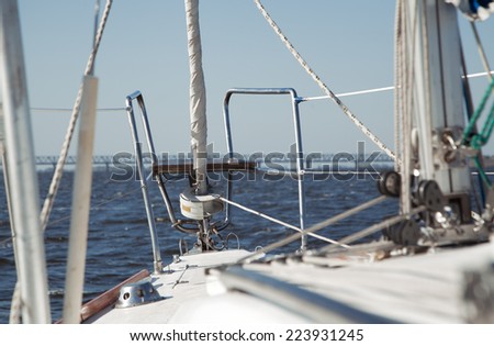 Rope and winch on a sailing vessel. View on deck of sailing yacht. Picture from perspective of sitting on deck of yacht