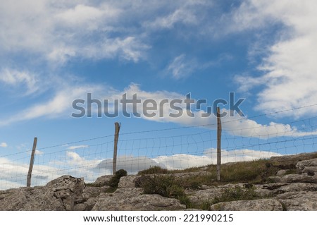 Wire fenced pastures in the mountains. Blue sky