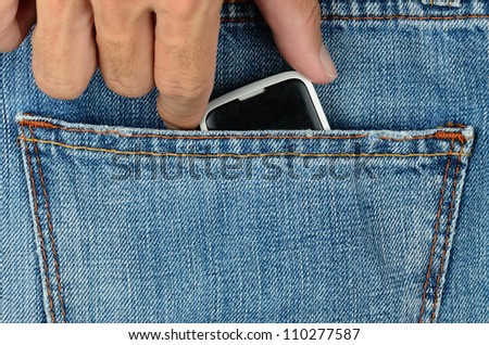 Mobile phone in blue jeans pocket being picking up by hand.