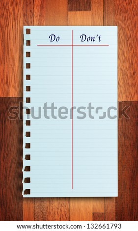 \'Do and Don\'t\' notice note on torn paper, wood background. Working concept.