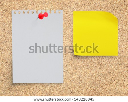White torn paper note and yellow sticker note paper with red pushpin on memo board