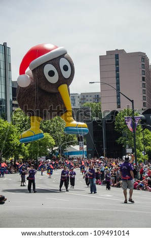 AUCKLAND, NEW ZEALAND - NOVEMBER 27 2011: Farmers employees carry a Kiwi bird balloon with a Christmas hat at the annual Christmas Parade on November 27, 2011 in Auckland, New Zealand.