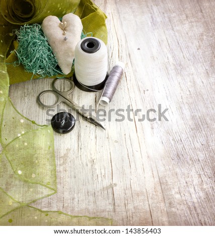 scrapbooking craft materials/Background with sewing tools and colored tape/Sewing kit. Scissors, bobbins with thread and needles on the old  wooden background