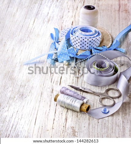 scrapbooking craft materials/Background with sewing tools and colored tape/Sewing kit. Scissors, bobbins with thread and needles on the old  wooden background