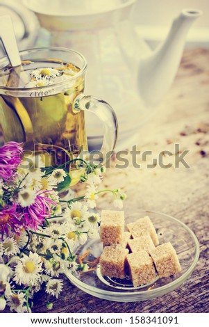 Cup of herbal  tea and summer flowers on wooden background/ romantic vintage background