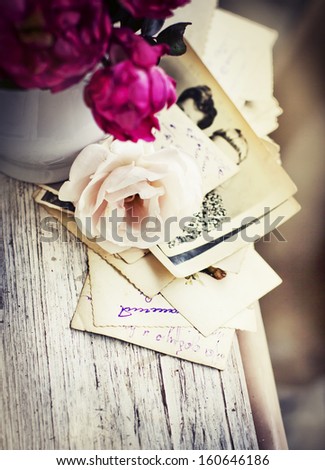 Beautiful roses with old letters and postcard on wooden background/ nostalgic romantic background