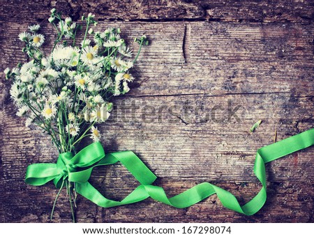 Beautiful Field white  flowers with the ribbon on wooden background/ spring rustic background with flowers