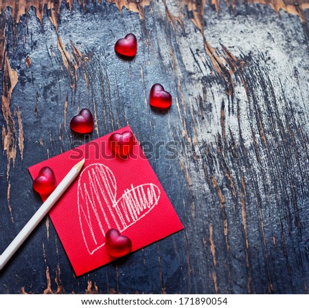 Red Valentines Day heart shaped candy border on dark texture wooden background