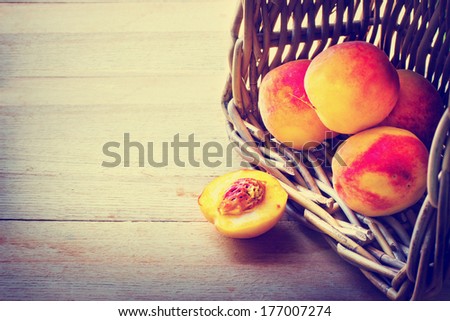 Peaches spilling out of a basket/ Ripe sweet peaches on wooden table