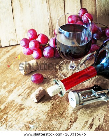 wine background with bottle of  red wine and glass on a old wooden table