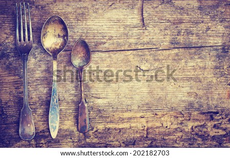Vintage silverware on rustic wooden plate