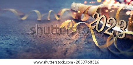 Photo of happy new year 2023  background new year holidays card with bright lights,gifts and bottle of сhampagne
