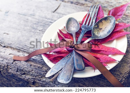 Thanksgiving table setting/ cutlery on the autumn background with autumn leaves,ribbon on wooden background/ Thanksgiving holidays background concept