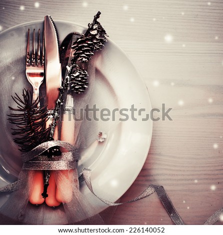 Christmas table place setting with christmas pine branches and plate, kine, fork ,ribbon and bow/ Christmas holidays background