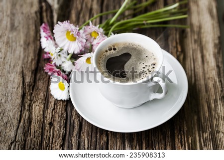 A cup of hot coffee, flowers and book. Romantic background with retro filter effect