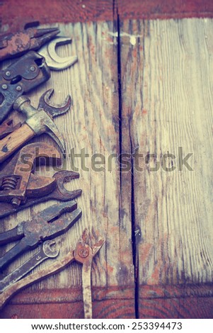 Dirty set of hand tools on a wooden panel/vintage background with a tools.