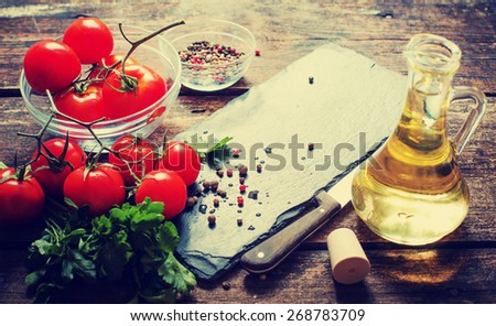 Ingredients for cooking and empty cutting board on an old wooden table. Food background with copyspace