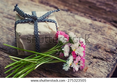 Flowers and present gift on wooden background/ Holiday background