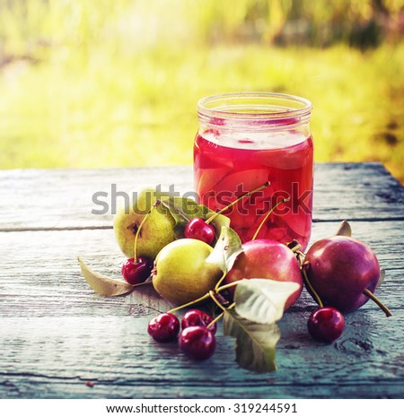 Glass of sweet homemade fruit compote on rusty table