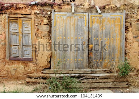Old rusty door and window of a ruined adobe house