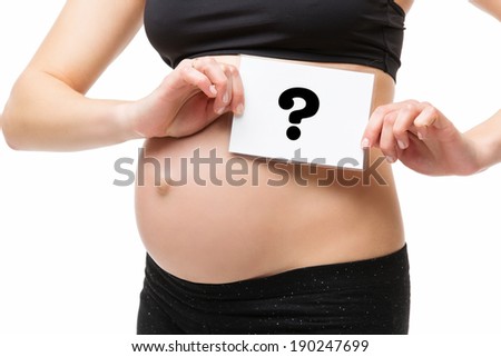 Pregnant woman holding white card with question mark near her belly