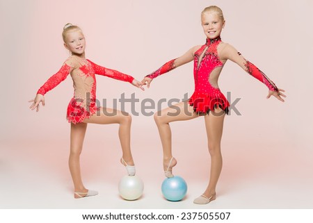 Two cute artistic gymnasts warming up in studio